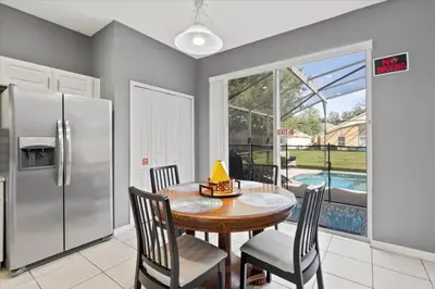 a kitchen with a table and chairs and a refrigerator at Family Fun Kissimmee Retreat in Kissimmee