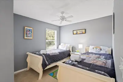 a bedroom with two beds and a ceiling fan at Family Fun Kissimmee Retreat in Kissimmee