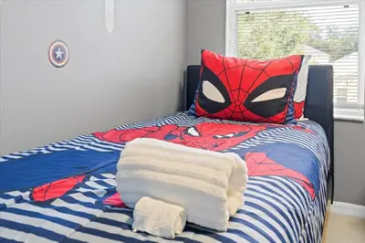 a bed with a spider man bedspread and a mask at Family Fun Kissimmee Retreat in Kissimmee