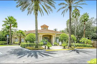 a house with palm trees in front of it at Family Fun Kissimmee Retreat in Kissimmee