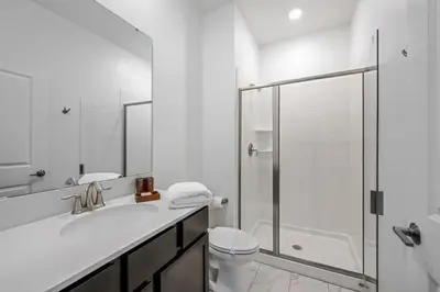 a white bathroom with a shower and a sink at Casa 4Q com Piscina Privativa e Temas Disney in Kissimmee