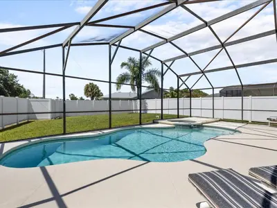 an indoor swimming pool with a glass roof at Sunny Getaway with Private Pool, Spa & Fenced Yard in Kissimmee