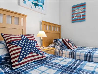 a bedroom with two beds with an american flag pillows at Sunny Getaway with Private Pool, Spa & Fenced Yard in Kissimmee