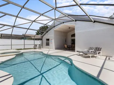 an indoor swimming pool with a glass roof at Sunny Getaway with Private Pool, Spa & Fenced Yard in Kissimmee