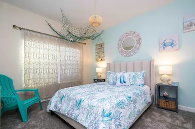 a bedroom with a bed and a blue chair at Magical Stay Mickey and Harry Potter Rooms in Kissimmee