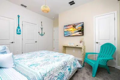 a bedroom with a bed and a blue chair at Magical Stay Mickey and Harry Potter Rooms in Kissimmee