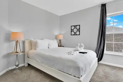 a white bedroom with a white bed and a window at 5BR Kissimmee Home Pool and Game Room Fun in Kissimmee
