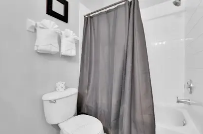 a bathroom with a shower curtain and a toilet at 5BR Kissimmee Home Pool and Game Room Fun in Kissimmee