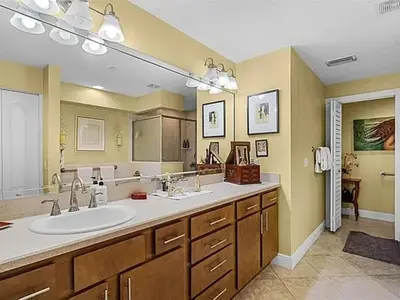 a bathroom with a sink and a large mirror at Spacious Lakefront Condo in Kissimmee in Kissimmee