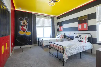 a bedroom with two beds and a mickey mouse mural at Fantasy Stay in 5 bed at Storey Lake in Kissimmee