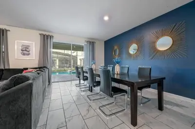 a dining room with a table and chairs and a blue wall at Villa Luxuosa 9Q c/ Piscina Privativa e Temas in Kissimmee