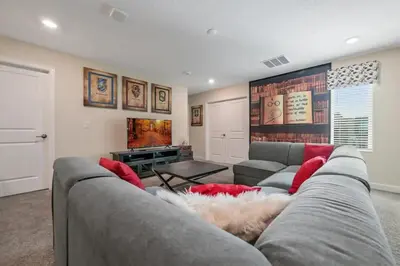 a living room with a gray couch and red pillows at Villa Luxuosa 9Q c/ Piscina Privativa e Temas in Kissimmee
