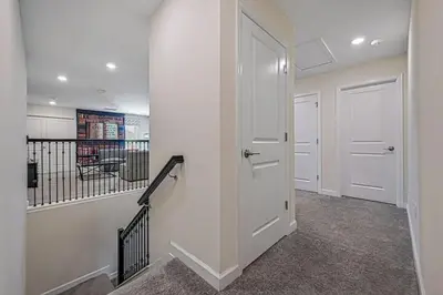 a hallway with two white doors and a staircase at Villa Luxuosa 9Q c/ Piscina Privativa e Temas in Kissimmee