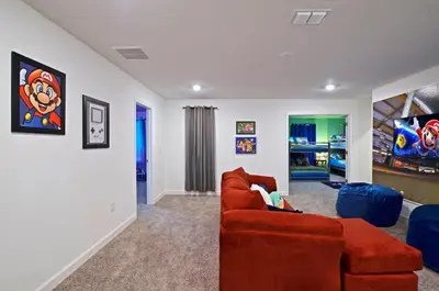 a living room with a red couch and a tv at 4213 - Lakeside Retreat in Kissimmee