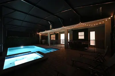 a swimming pool in the middle of a house at night at 2956 - Sanctuary at Storey Lake in Kissimmee