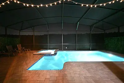an indoor swimming pool in a tent with lights at 2956 - Sanctuary at Storey Lake in Kissimmee