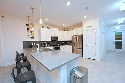 a large kitchen with white cabinets and a counter top at 2956 - Sanctuary at Storey Lake in Kissimmee