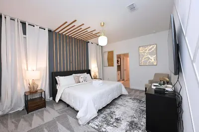 a bedroom with a white bed and a television at 2956 - Sanctuary at Storey Lake in Kissimmee