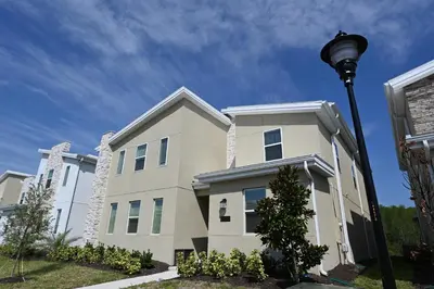 a white house with a street light in front of it at 2956 - Sanctuary at Storey Lake in Kissimmee