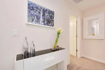 a white living room with a fireplace and a vase of flowers at Viva o Luxo – 5 Quartos e Piscina no Resort in Kissimmee