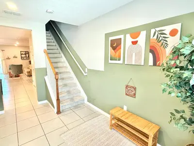 a living room with stairs and a stair case at Boho retreat close to Disney! in Kissimmee