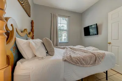 a bedroom with a bed and a television on the wall at Comfy Townhome Minutes from Disney in Orlando