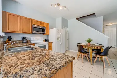 a kitchen with a counter and a table with chairs at Comfy Townhome Minutes from Disney in Orlando