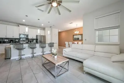 a living room with a white couch and a table at Férias Perfeitas! Casa 4Q+Piscina perto Disney in Kissimmee