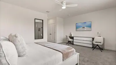 a white bedroom with a bed and a desk at Upstay-Luxury 3BR Home w Private Pool & Games Room in Orlando