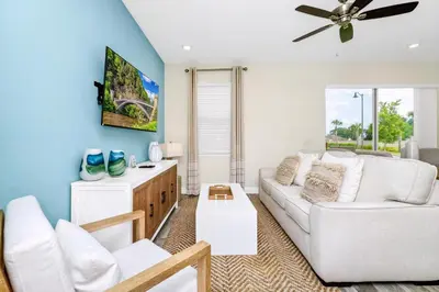 a living room with a white couch and a ceiling fan at Cheerful Villa Near Disney With Margaritaville Resort And Island H20 Waterpark Access - 2913Cs in Orlando
