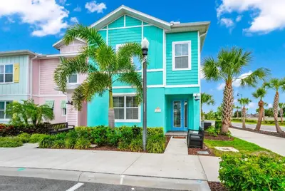 a pink and blue house with palm trees at Cheerful Villa Near Disney With Margaritaville Resort And Island H20 Waterpark Access - 2913Cs in Orlando