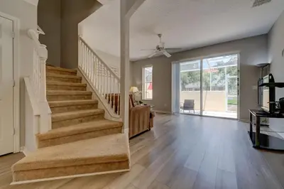 a large living room with a staircase and a stair case at Cozy Vacation Retreat in Fiesta Key Community in Kissimmee
