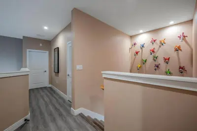a hallway of a home with paintings of butterflies on the wall at Elegant Orlando Getaway Close To Disney in Kissimmee