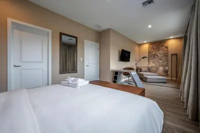 a bedroom with a white bed and a living room at Luxury Family Townhouse Near Disney & Dining in Kissimmee