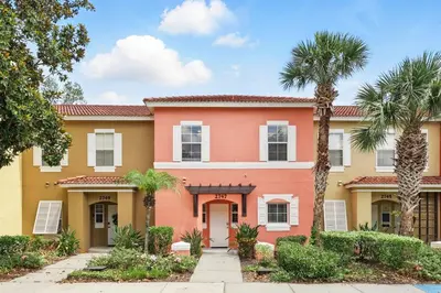 a house with palm trees in front of it at Family Escape Near Disney Serene Retreat in Terra Verde Resort in Kissimmee