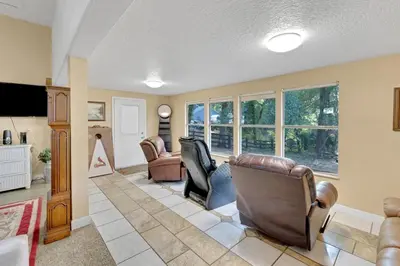 a living room with leather chairs and a living room with windows at Orlando 3BR | Hot Tub + Parking + Pets in Orlando