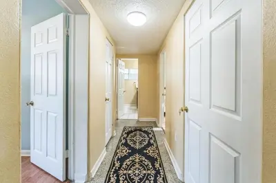 a hallway with doors and a rug at Orlando 3BR | Hot Tub + Parking + Pets in Orlando