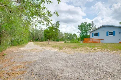 a dirt road in front of a blue house at 15 Mi to Dtwn Orlando Spacious Family Home in Orlando