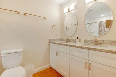 a bathroom with a toilet and a sink and a mirror at 15 Mi to Dtwn Orlando Spacious Family Home in Orlando
