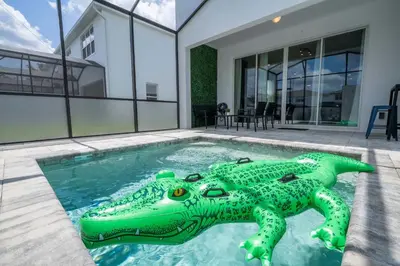 a green inflatableigator in a swimming pool in a house at Family Friendly w Pool near Disney at Serenity 1420 in Orlando