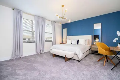 a bedroom with a bed and a blue wall at Family Friendly w Pool near Disney at Serenity 1420 in Orlando