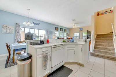 a kitchen with white cabinets and a staircase at 10 Mi to Disney Parks Resort Retreat with Patio in Kissimmee