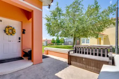 a porch with a bench next to a door at 10 Mi to Disney Parks Resort Retreat with Patio in Kissimmee