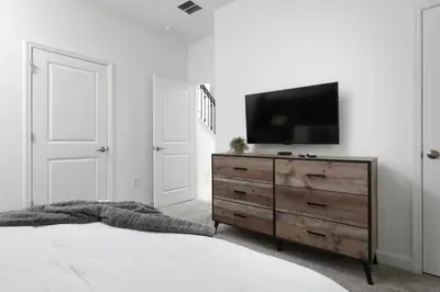 a bedroom with a dresser with a television on it at Townhome 4Q Storey Lake c/ Piscina Privada in Kissimmee