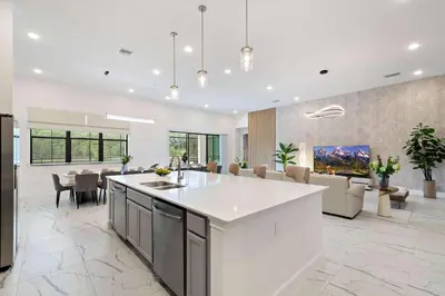 an open kitchen and living room with a dining room at Grand 15-Bedroom Villa -Magical Themes, Pool & Game Loft, Lakeview in Kissimmee
