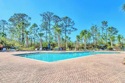 a swimming pool with trees in the background at Upstay Modern 3BR Getaway w Pool in Orlando