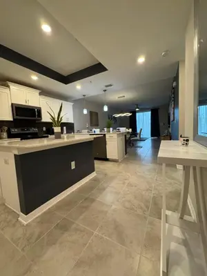 a large kitchen and living room with white cabinets at 2 Bedrooms Apartment in Storey Lake in Kissimmee