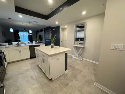 a large kitchen with white cabinets and a counter top at 2 Bedrooms Apartment in Storey Lake in Kissimmee