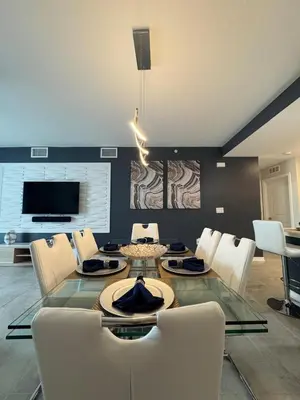 a dining room with a glass table and white chairs at 2 Bedrooms Apartment in Storey Lake in Kissimmee