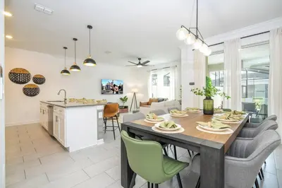 a kitchen and living room with a table and chairs at Stylish Home & Free Resort Access 2420 in Kissimmee